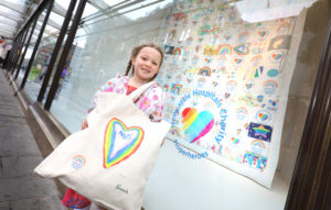 Photo of Lilly holding her design featured on the tote bag