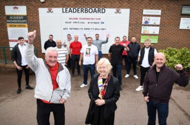 Charity golf group smiling.