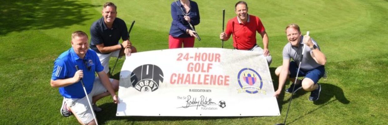 Lady Elsie and group holding 24 hour golf challenge poster on putting green.