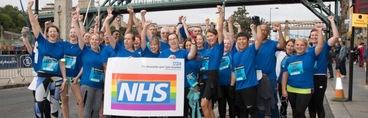 Group of people stood under the Tyne Bridge after completing the Great North Run.
