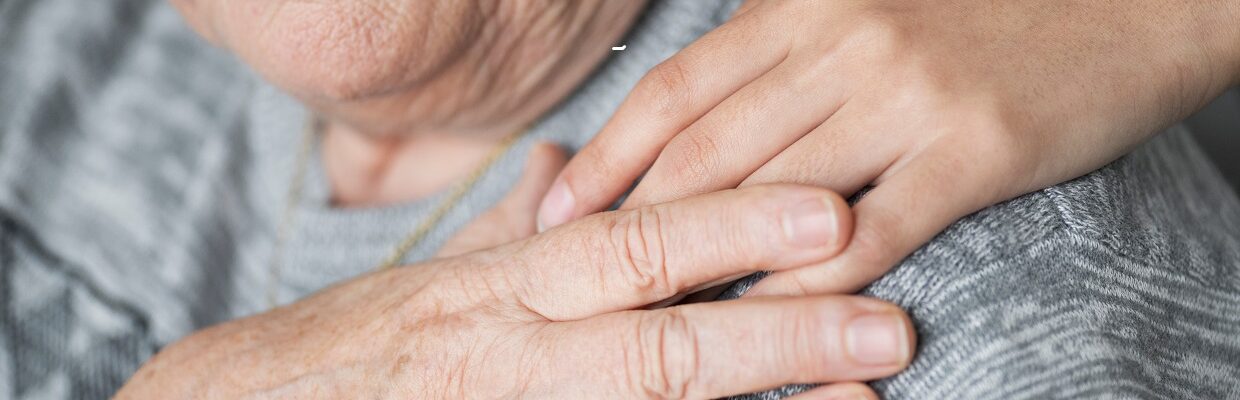 Persons hand on someones shoulder.